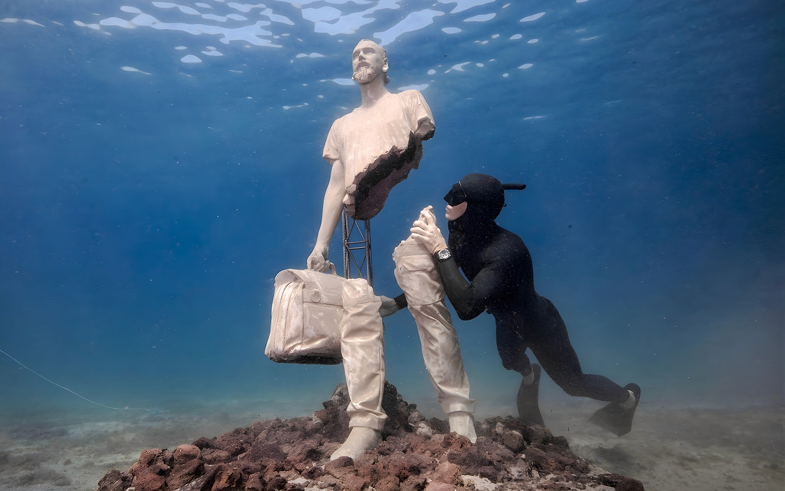 Diver exploring statue in Underwater Museum of Marseille.