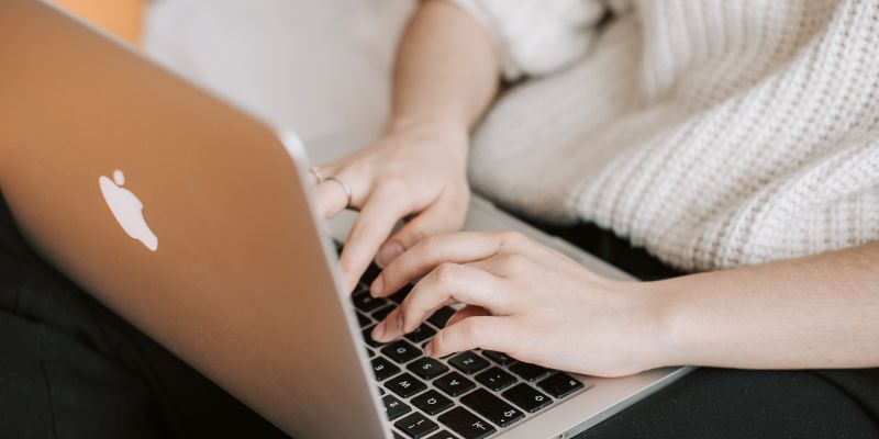 A Malaysian woman typing on her laptop