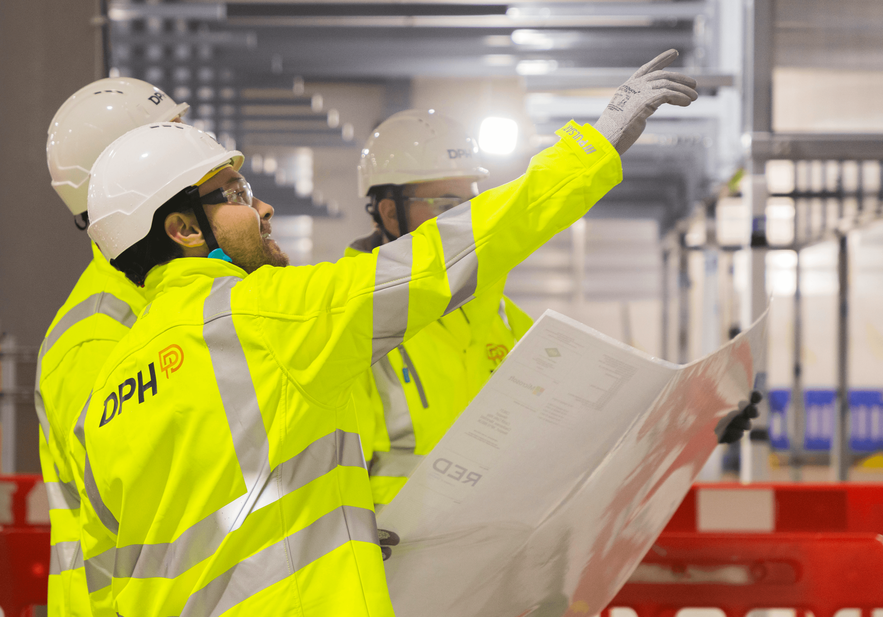 Modern glass building with illuminated interior and reflections at sunset