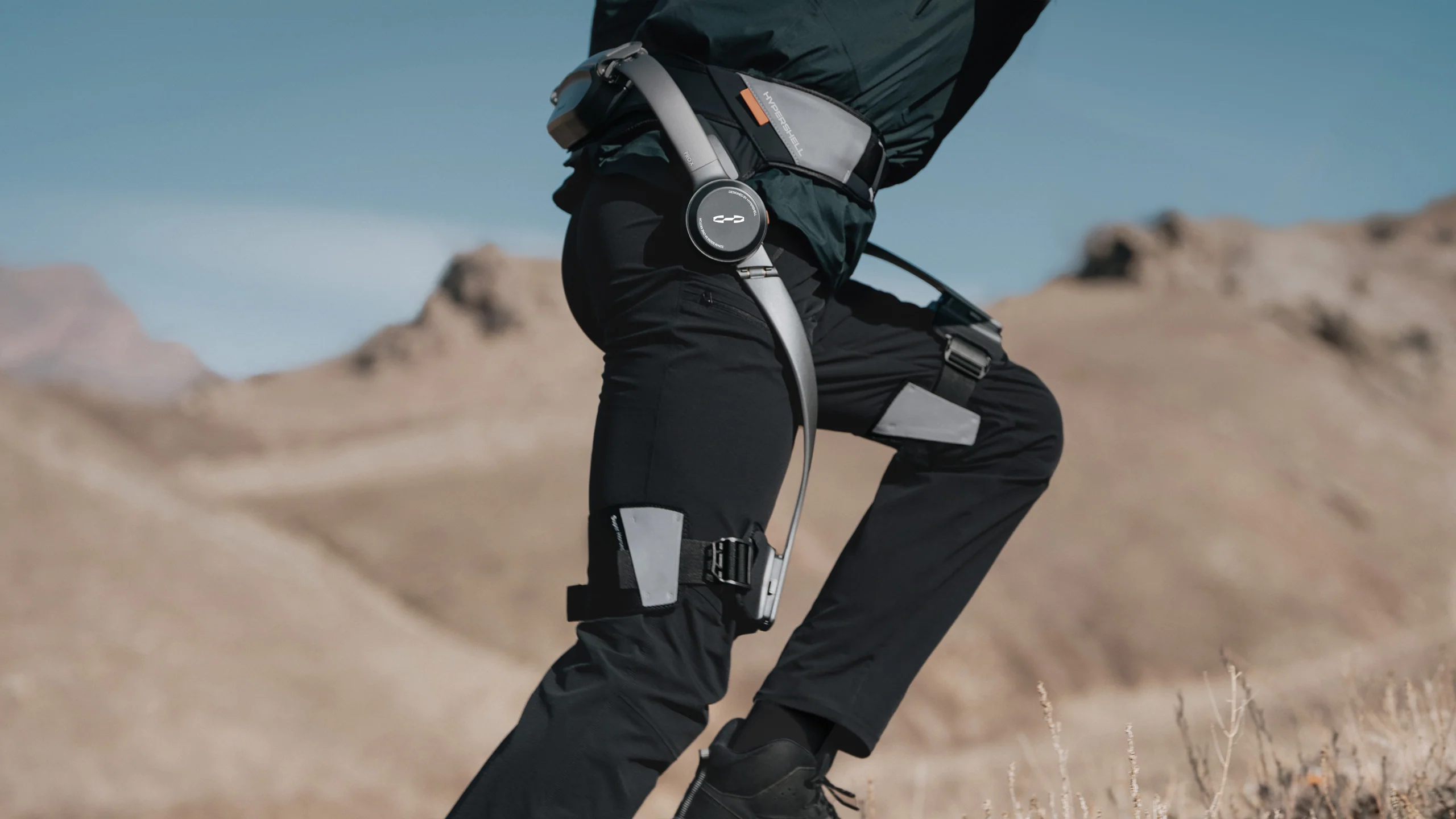 Personne portant l’exosquelette motorisé Hypershell X Pro en randonnée, illustrant son design léger et son système d’assistance aux jambes en action.