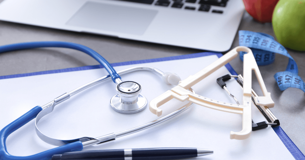 Medical tools and tape measure on desk for weight loss clinic bookkeeping