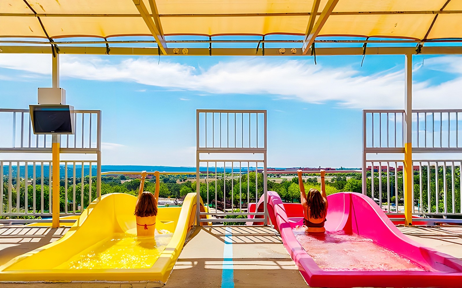 Children on colorful water slides at Aquopolis Villanueva de la Cañada.