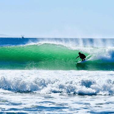 Surfer riding a green wave – surfboard rental in santa-barbara.