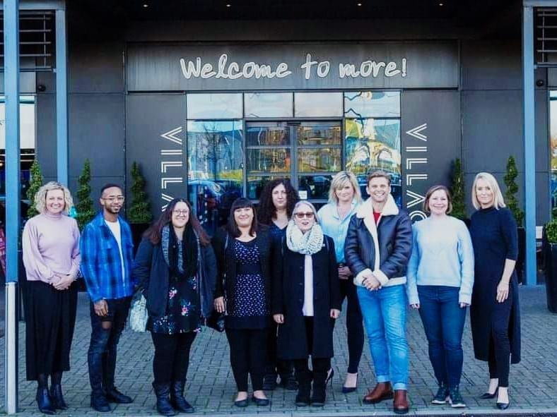 Group of people standing in front of the Village hotel
