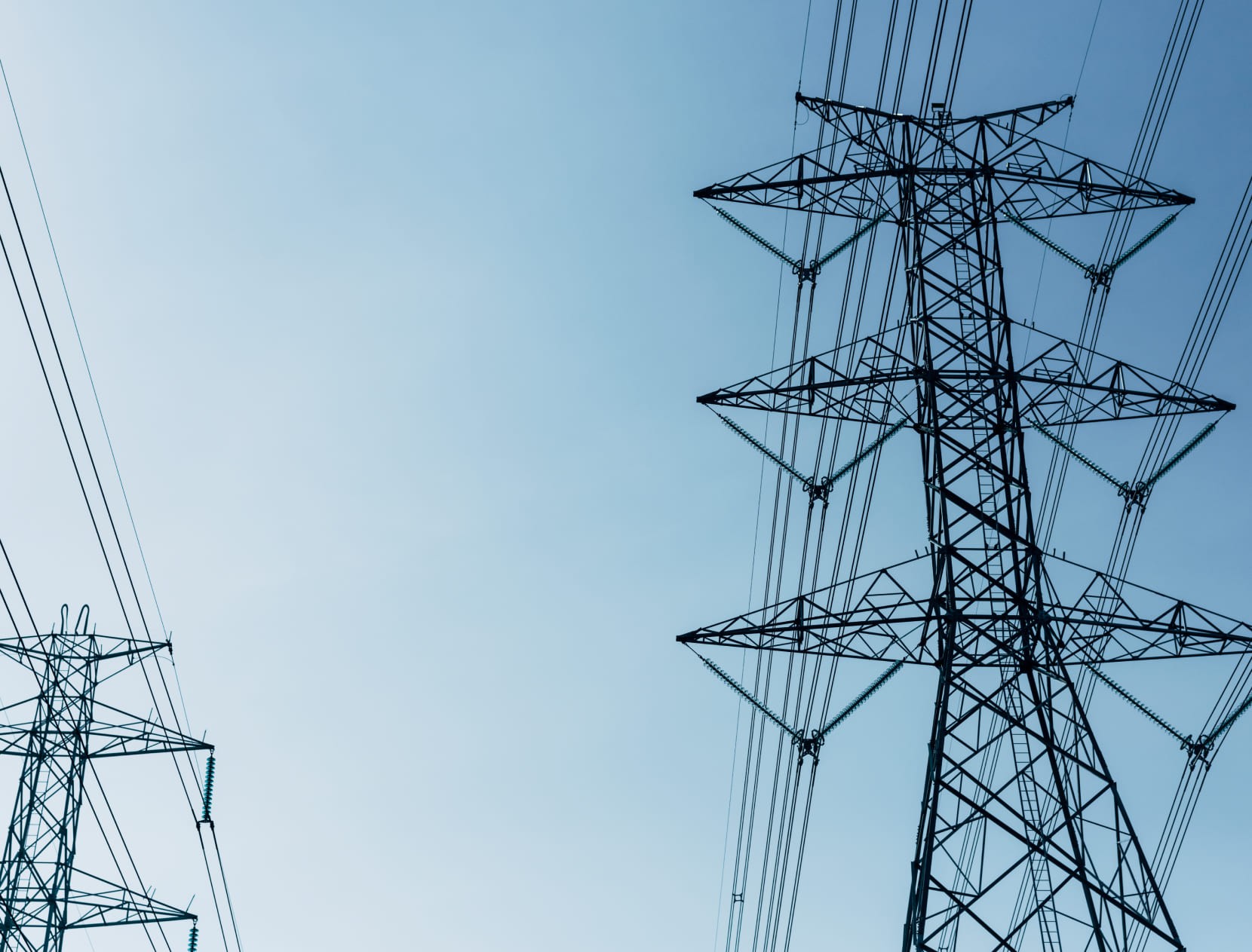 Electricity transmission towers against a blue sky
