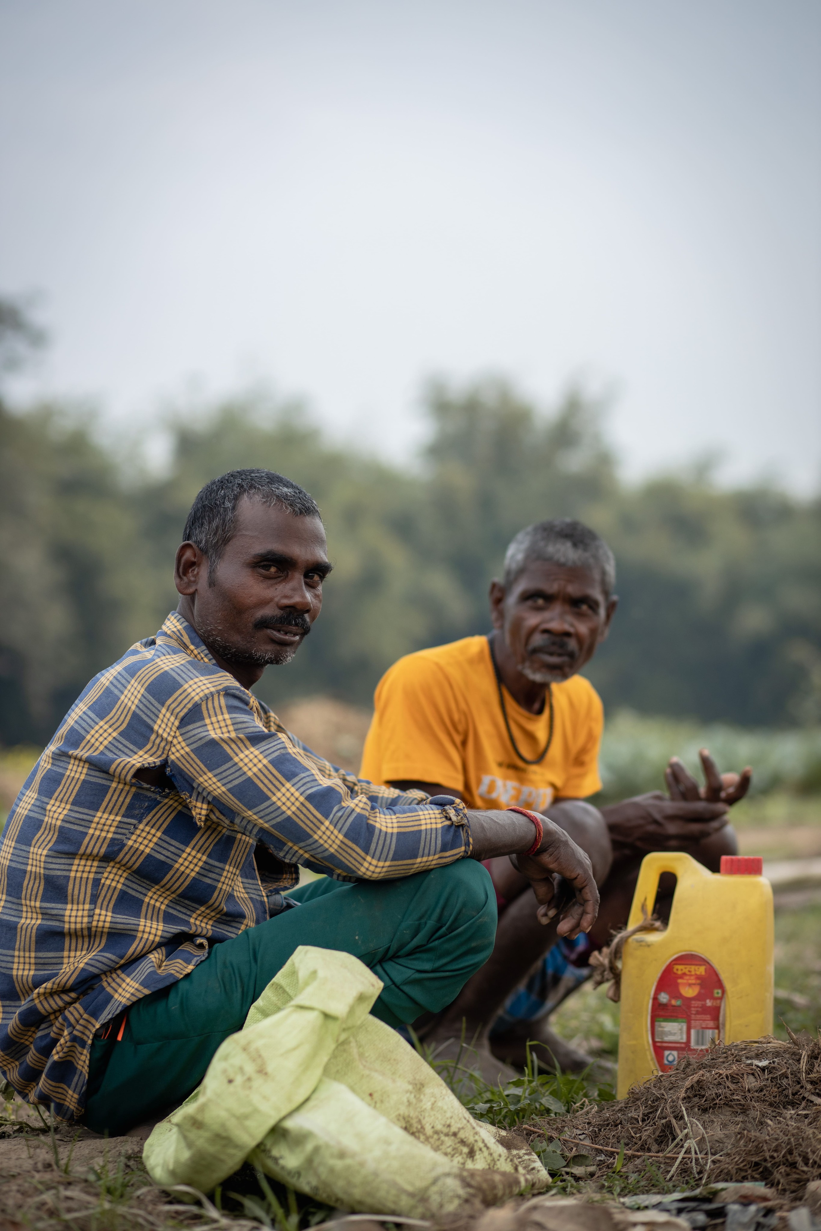 Two men from Madhya Pradesh sitting beside a field ready for harvest and store it in Sunmeister solar energy cold room