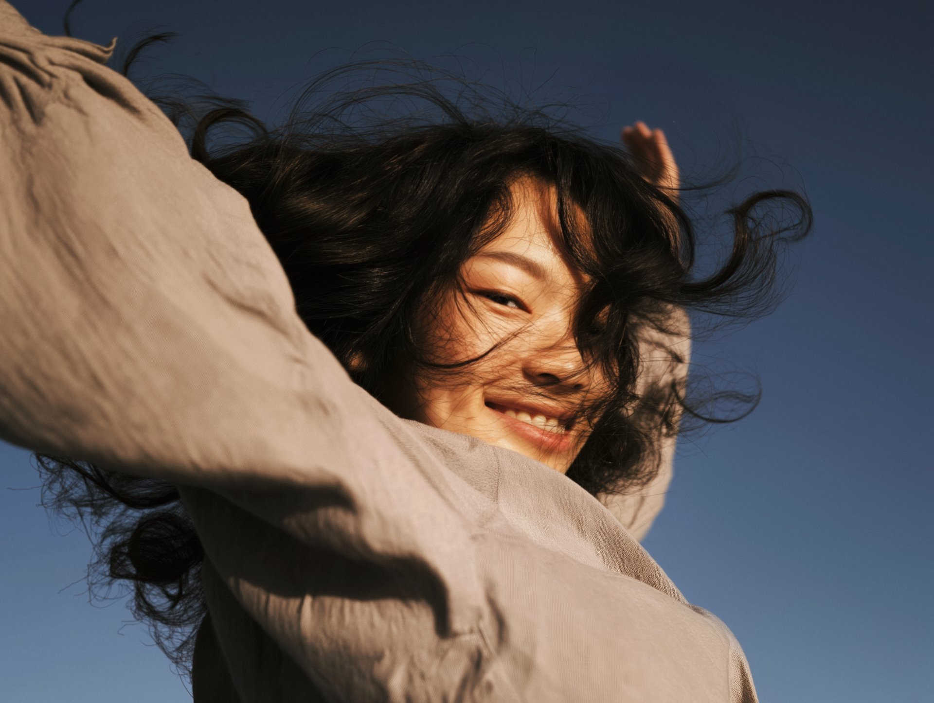 Laughing woman against a clear blue sky