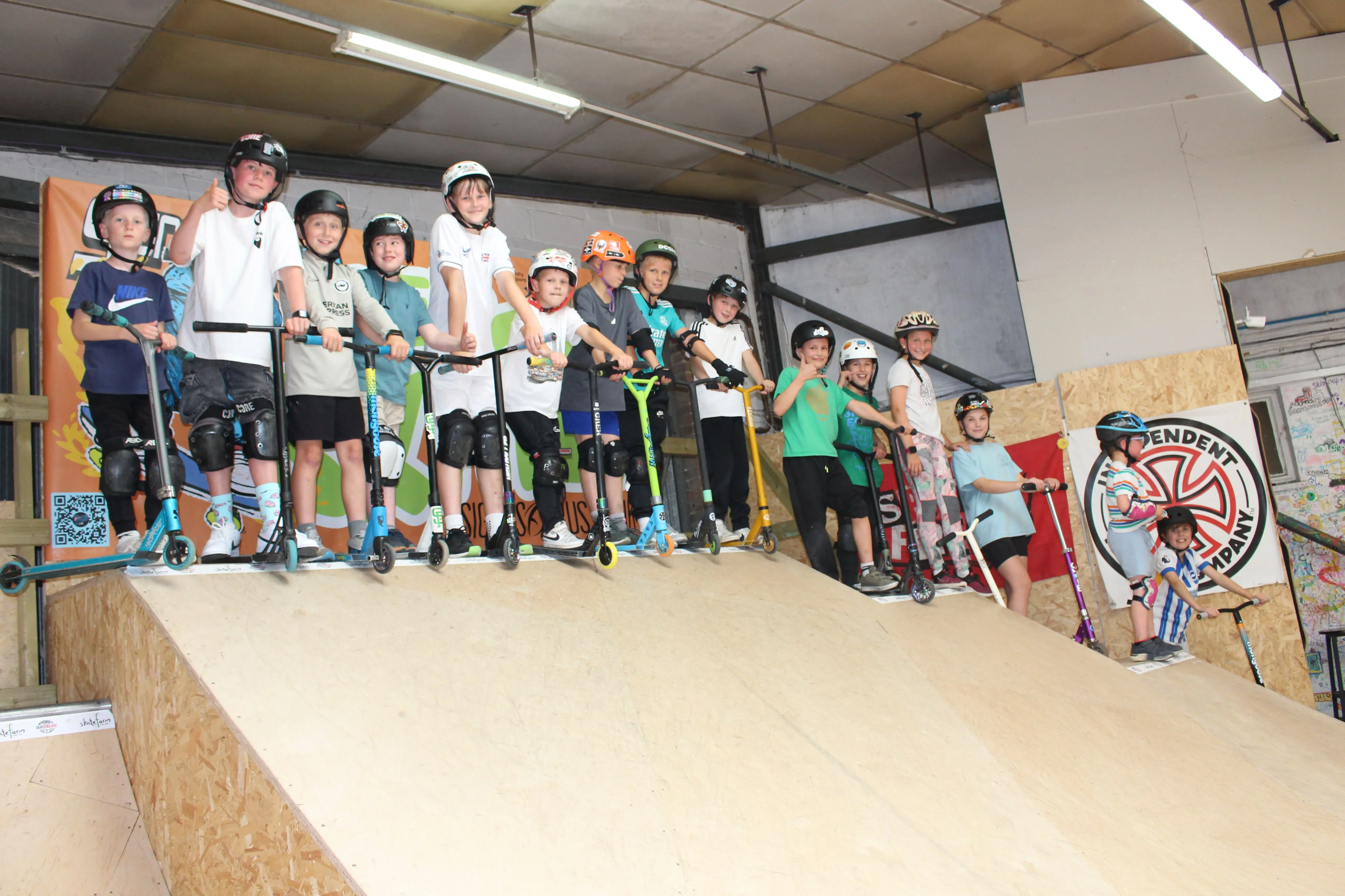 Young skateboarder performing a grab trick off the mini ramp at The Skate Farm indoor skatepark in Haywards Heath