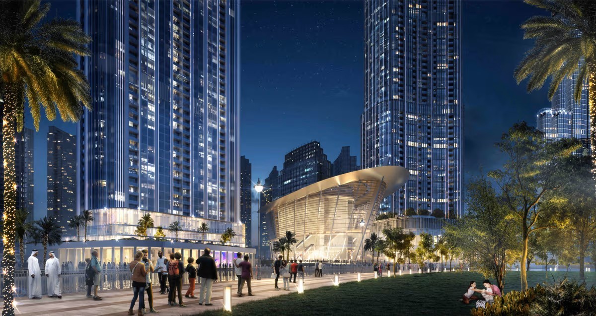 Öffentlicher Platz mit modernen Wolkenkratzern und einer futuristischen Architektur bei Nacht in Dubai.