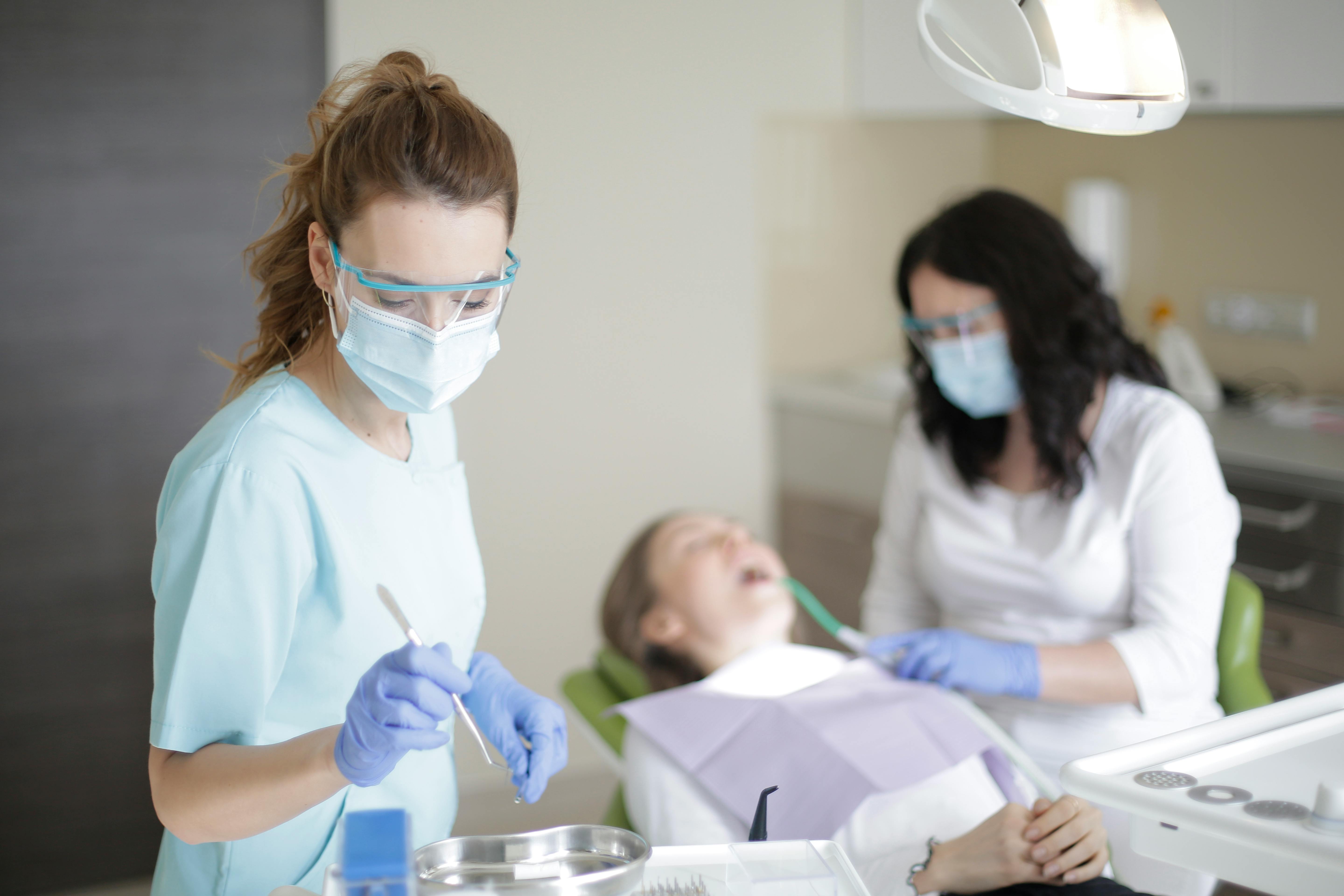 dental hygienists working on a patient in a dental chair