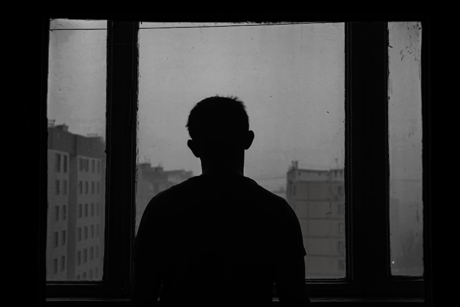 The host seated in deep shadow beside a window