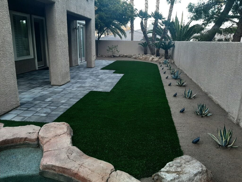 FreshStart Landscaping Vegas backyard with artificial turf lawn paver patio and desert plants