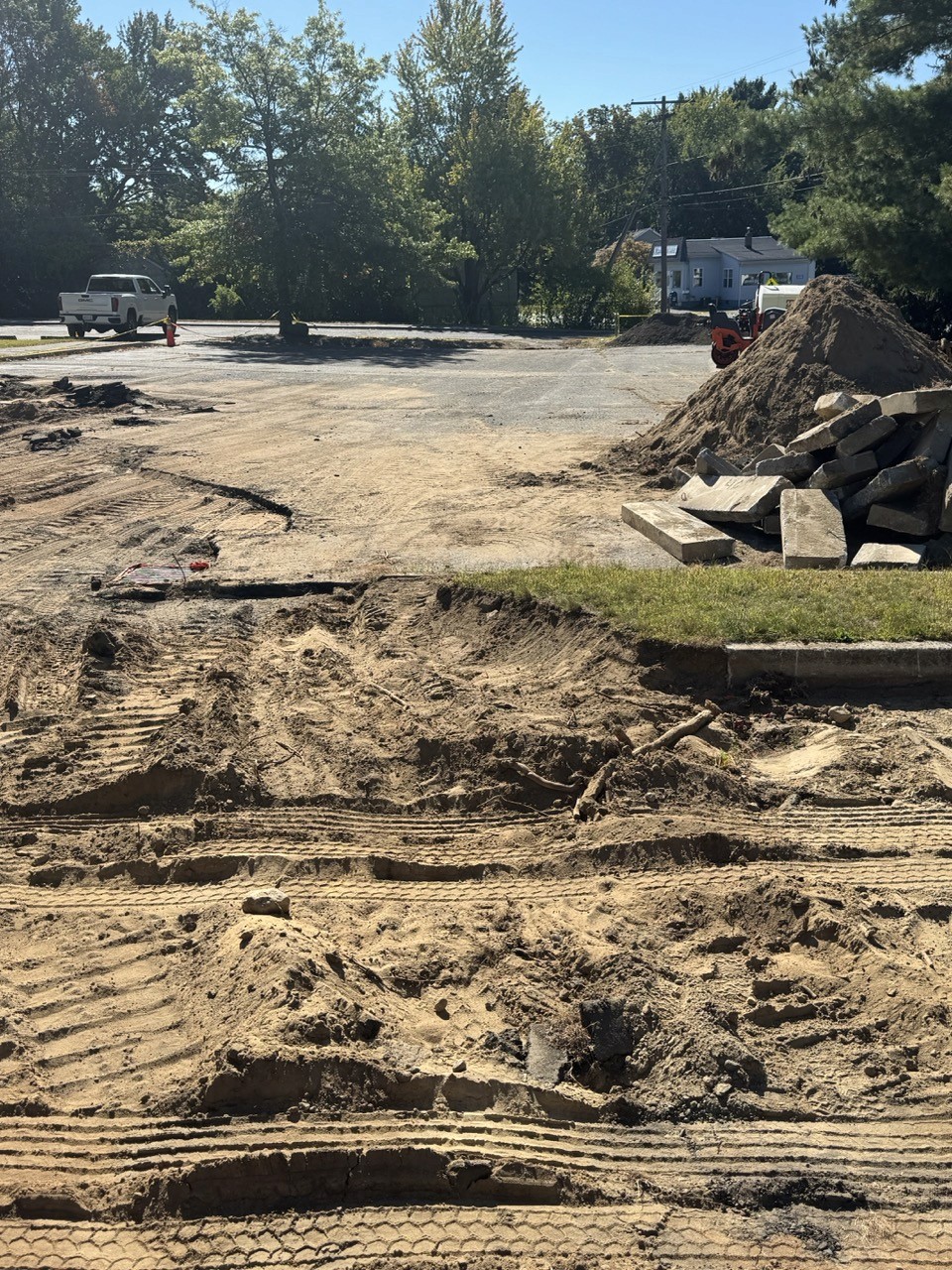 Graded site with new curbing and material stockpiles
