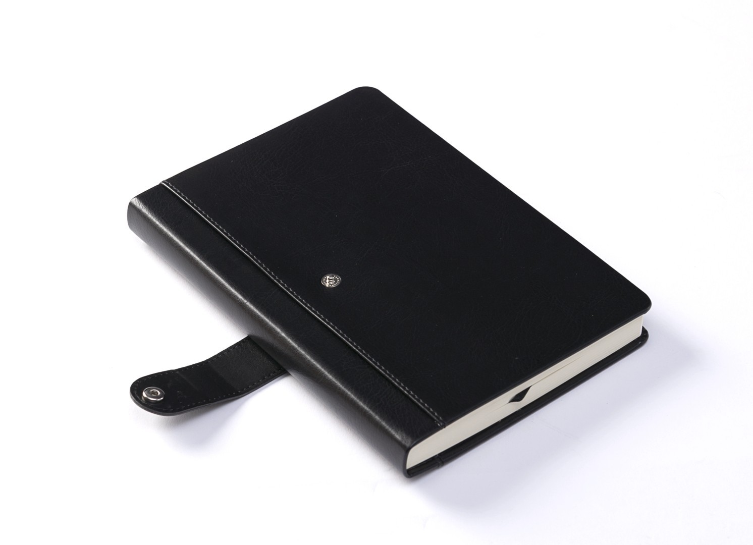 Angled view of black notebook with open snap button strap.