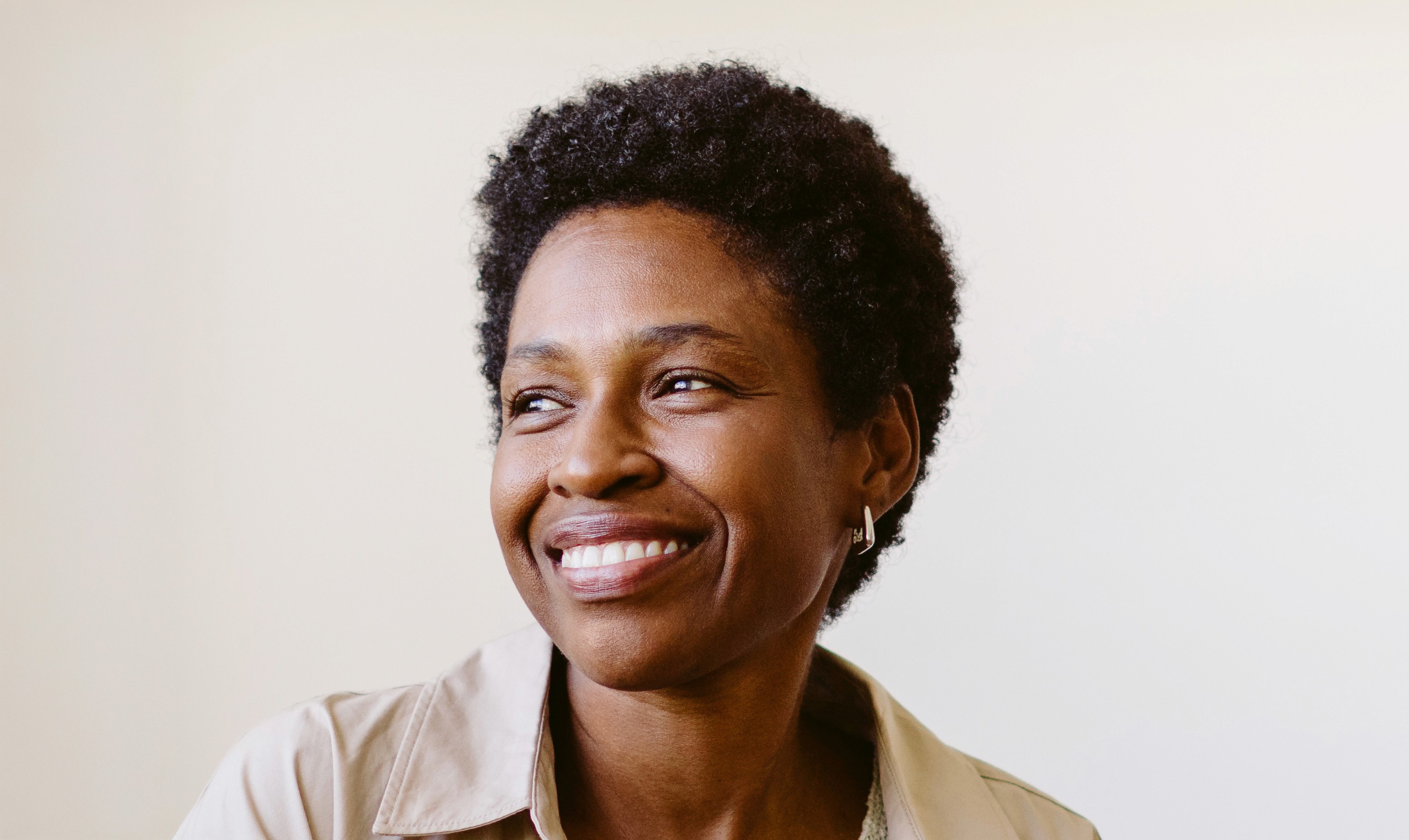 Woman with brown curly hair smiling