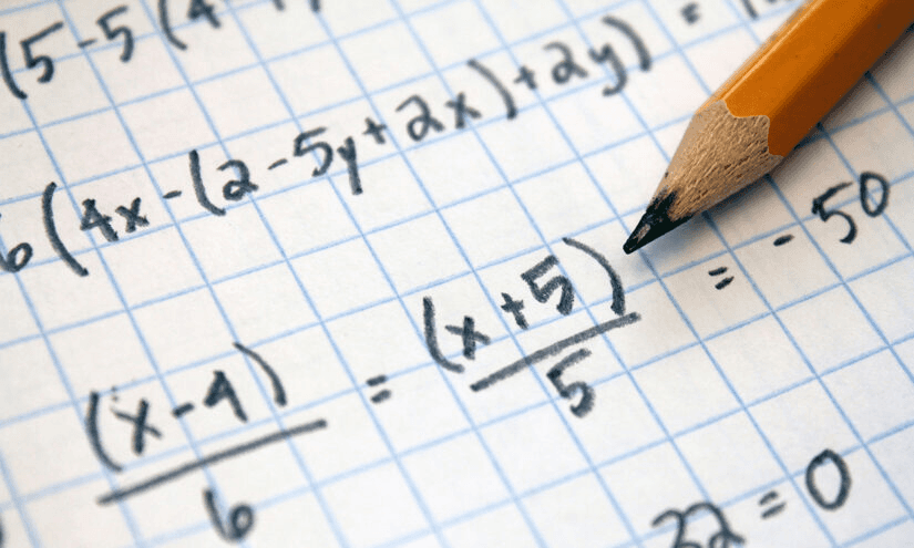 High school student working on mathematics research project with graphs and data on a desk