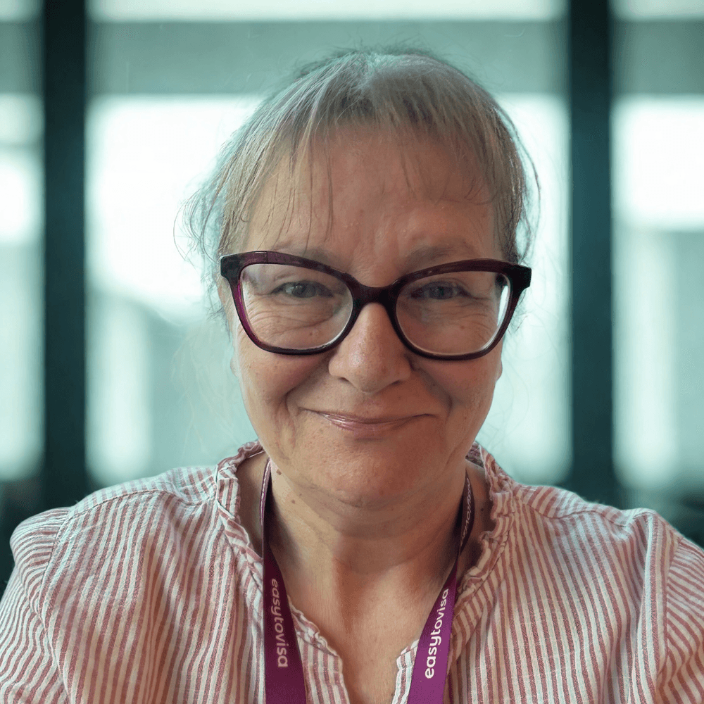 three men laughing while looking in the laptop inside room