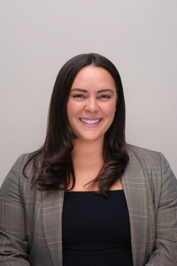 Professional headshot of a woman in a gray blazer