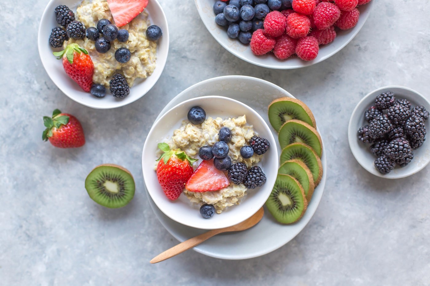 Bowls of oatmeal with berries and kiwi, illustrating the protein, fiber, and fresh foods that give a GLP-1 its nutritional foundation.