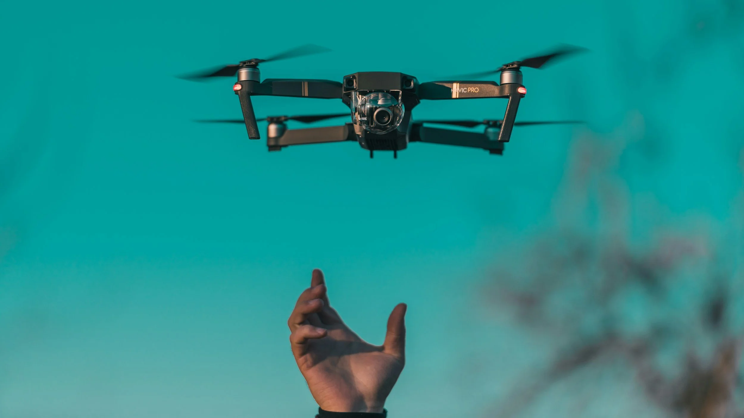 A drone flying in the air with an exgtended hand beneath