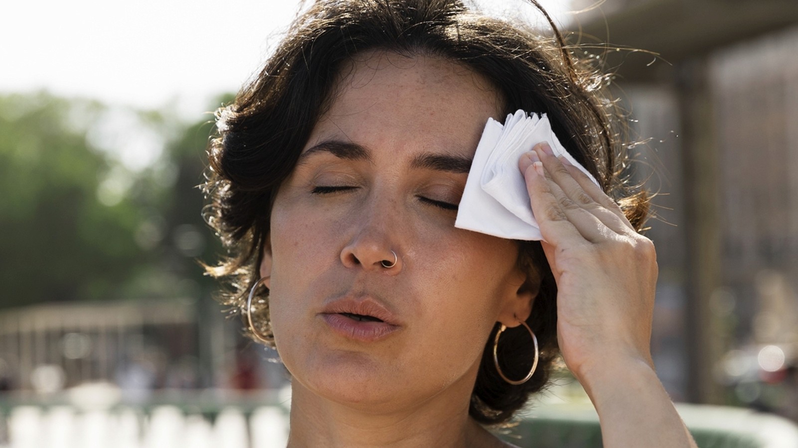 Mulher com calor secando suor