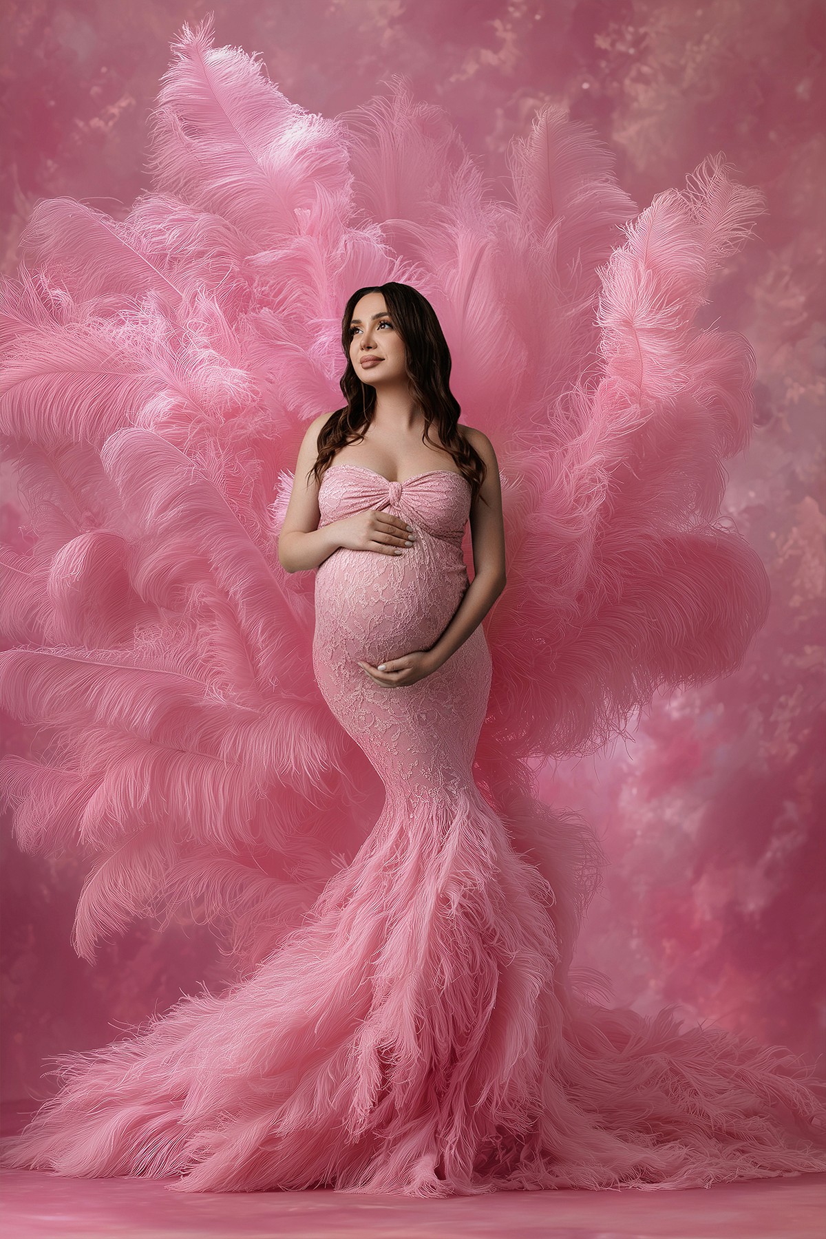 Studio maternity photoshoot featuring a fluffy gown and soft pastel background.