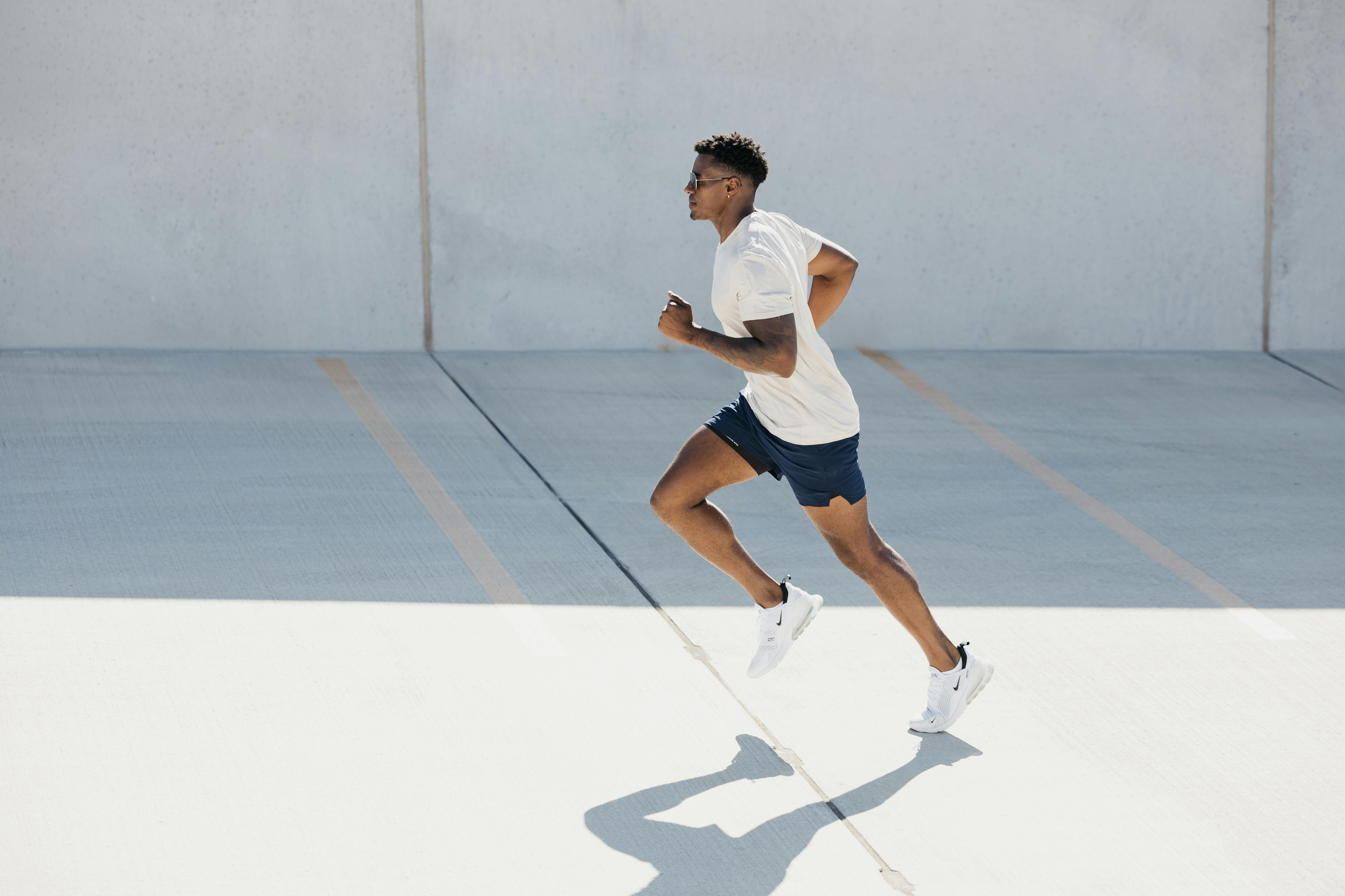 Man running in a sports outfit in a sunny environment.