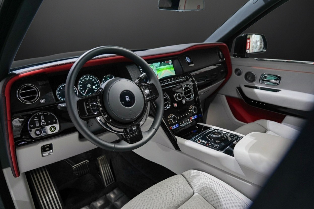 Front seats interior of Rolls-Royce Cullinan Black Badge 2023, white leather with red details and luxury craftsmanship