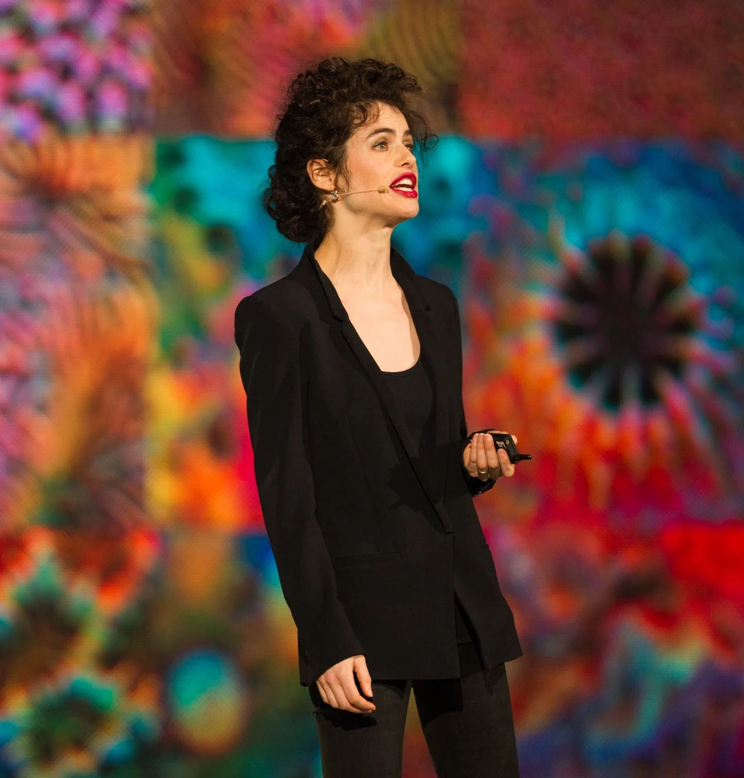 Speaker presenting on stage during a C2 conference talk, sharing ideas on creativity, culture, and innovation.