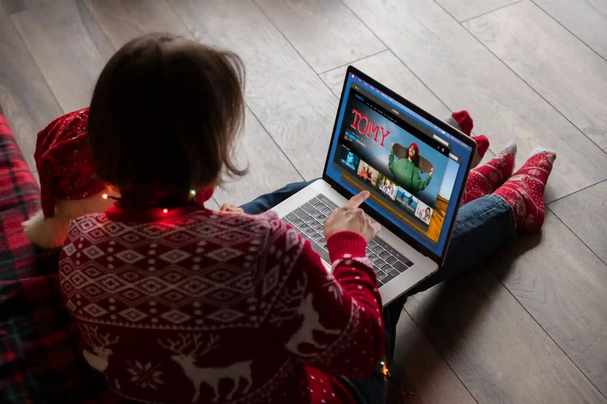  A woman in a festive Christmas sweater browses accurate product listings on her laptop to avoid negative shopping experiences.