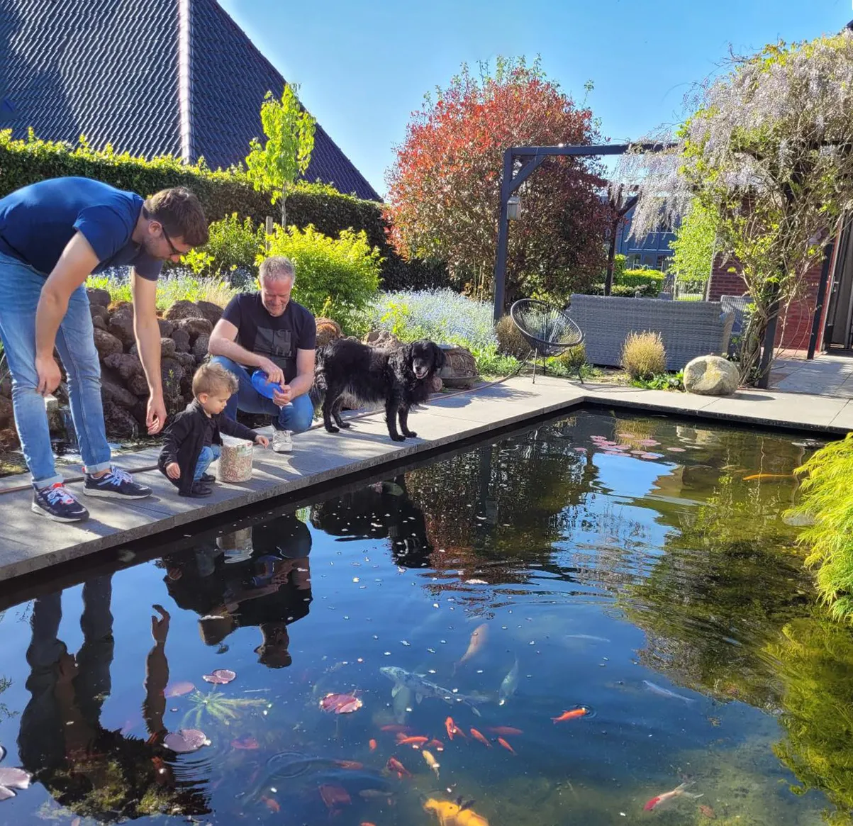 Feitze Dijkstra met kind en hond bij siervijver in aangelegde tuin in Friesland