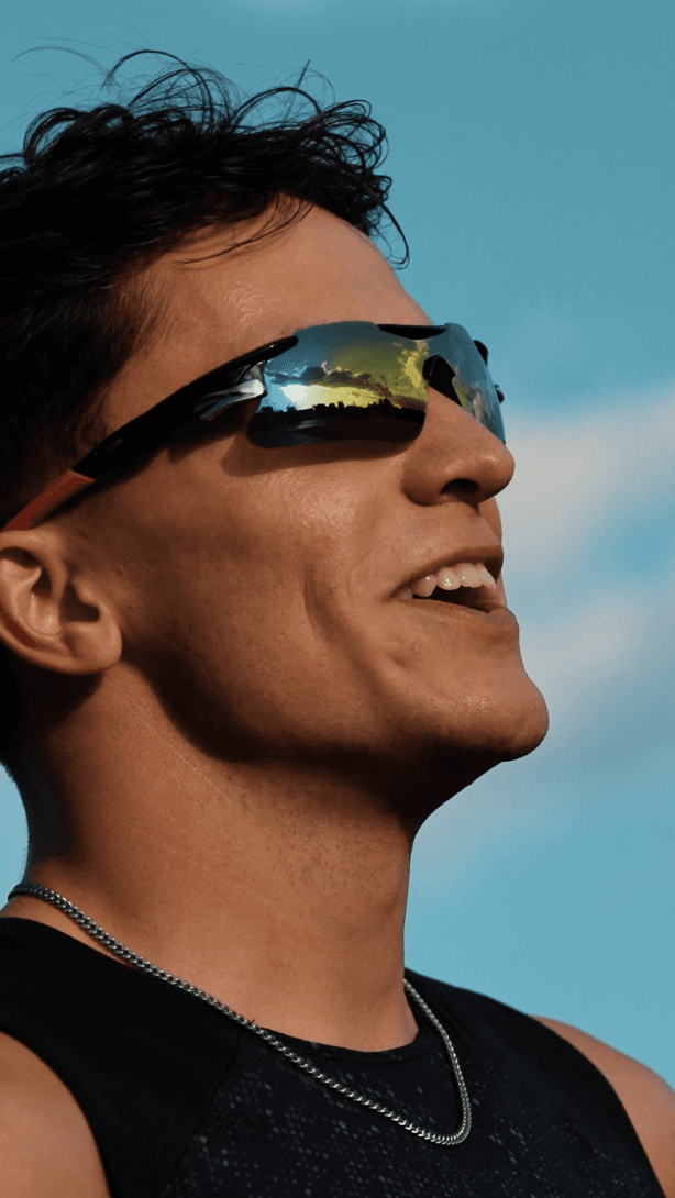 Bride sitting on ground against wall, groom standing nearby