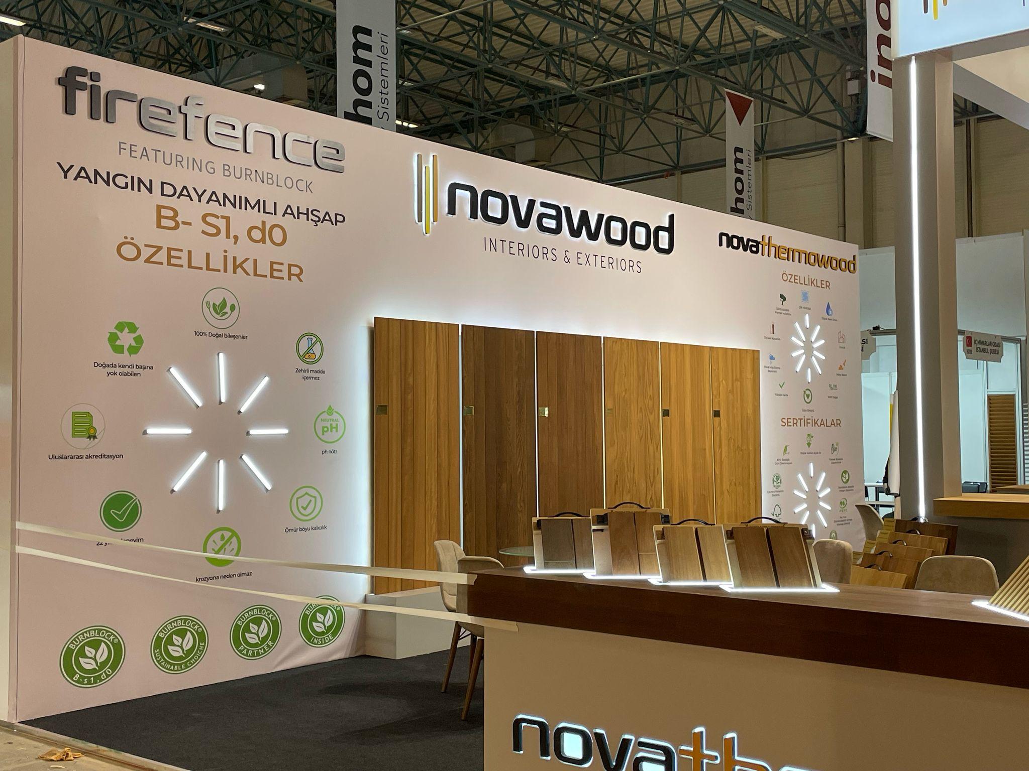 Wall‑mounted wood panels and informative graphic walls at the Novawood stand, explaining product features and certifications.
