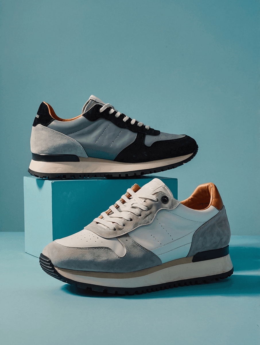 Two pairs of multi-colored athletic sneakers displayed on a blue block.