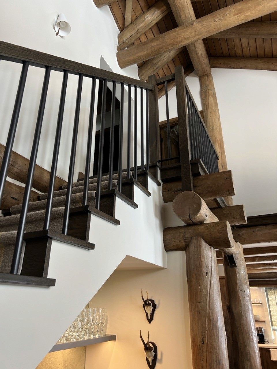 Stairs and upper landing in the Mid Valley remodel, dark wood treads with black steel balusters.