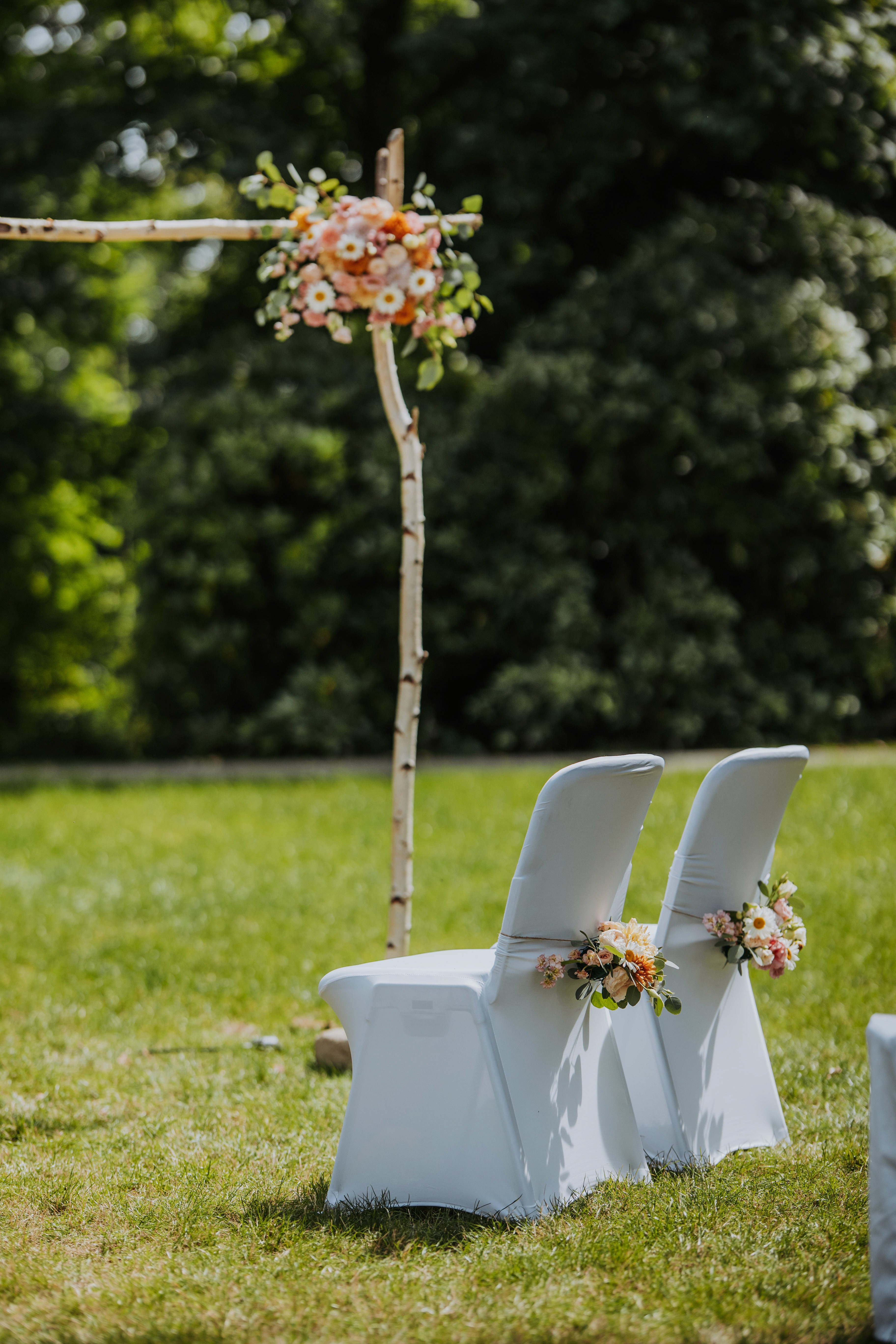 Junge Frau in beige kariertem Blazer sitzt an gedecktem Tisch.