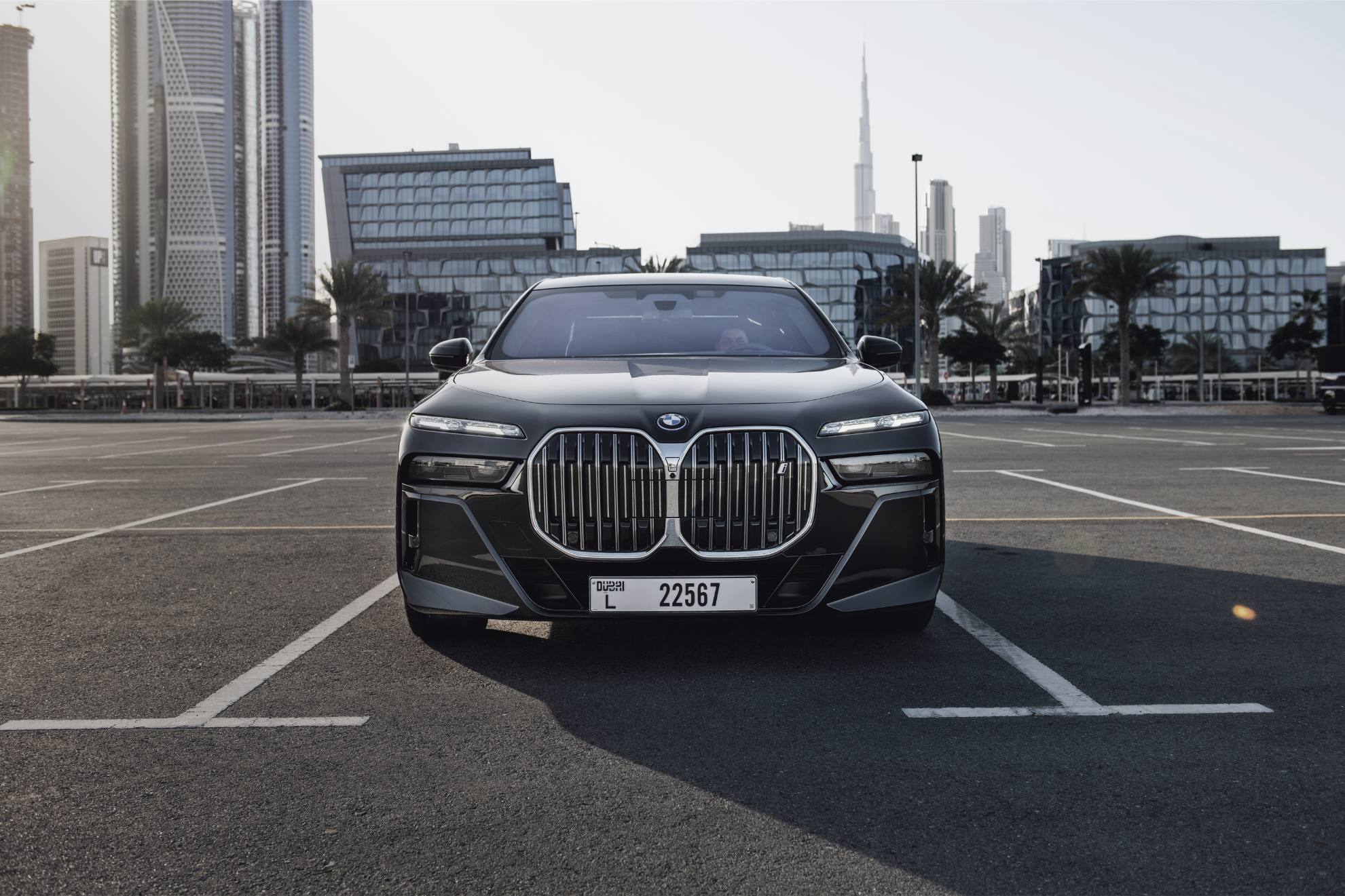 bmw i7 parked with a cityscape in the background