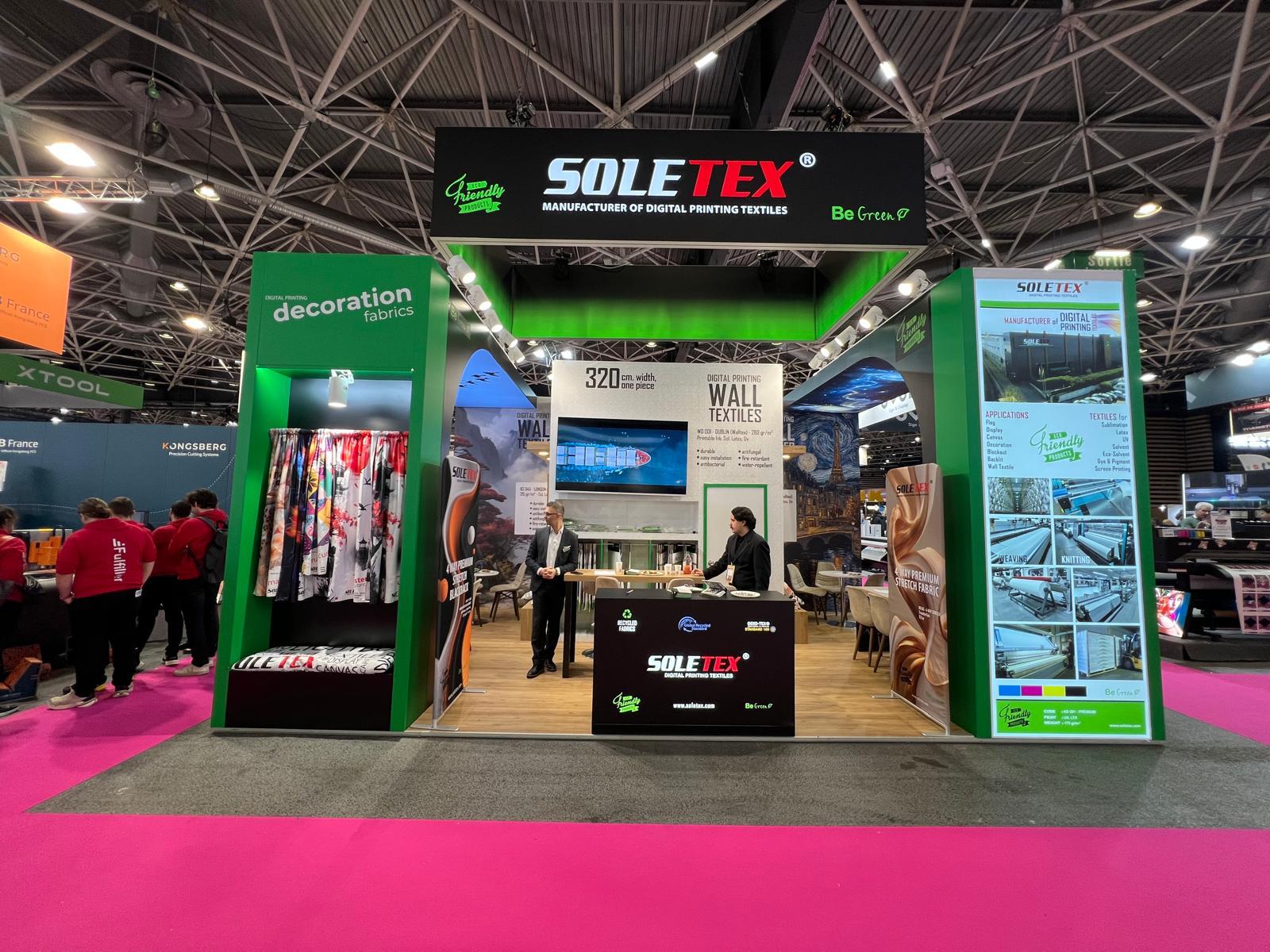 SOLETEX exhibition stand at CTCO Lyon 2026, featuring strong black and green corporate branding, printed textile graphics, and warm wooden flooring.