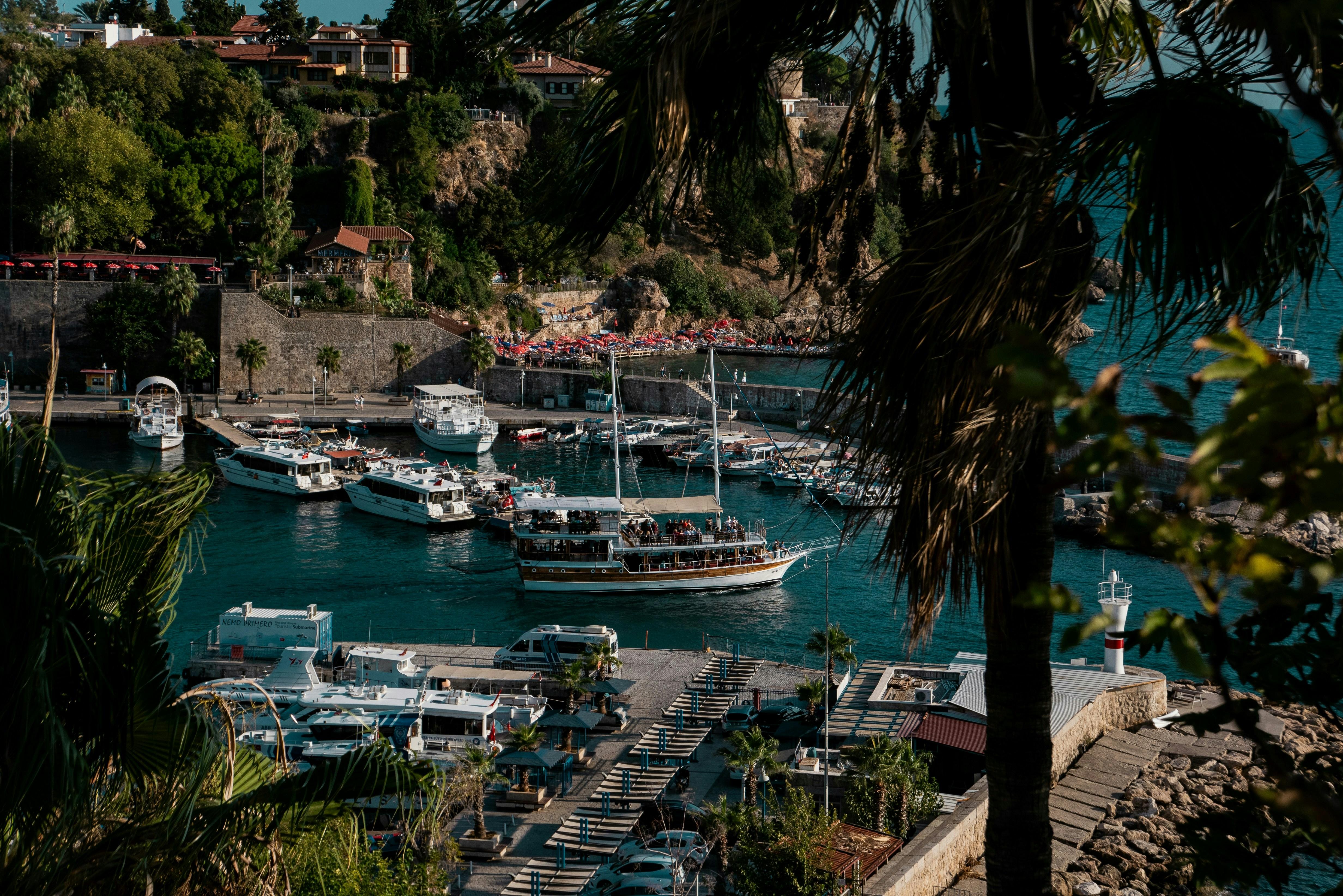 A harbor filled with lots of boats next to a lush green hillside