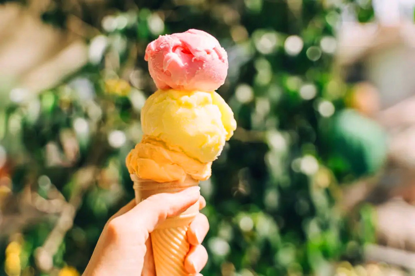 Close-up of a yellow tennis ball sitting on a green court, positioned near the white center line.