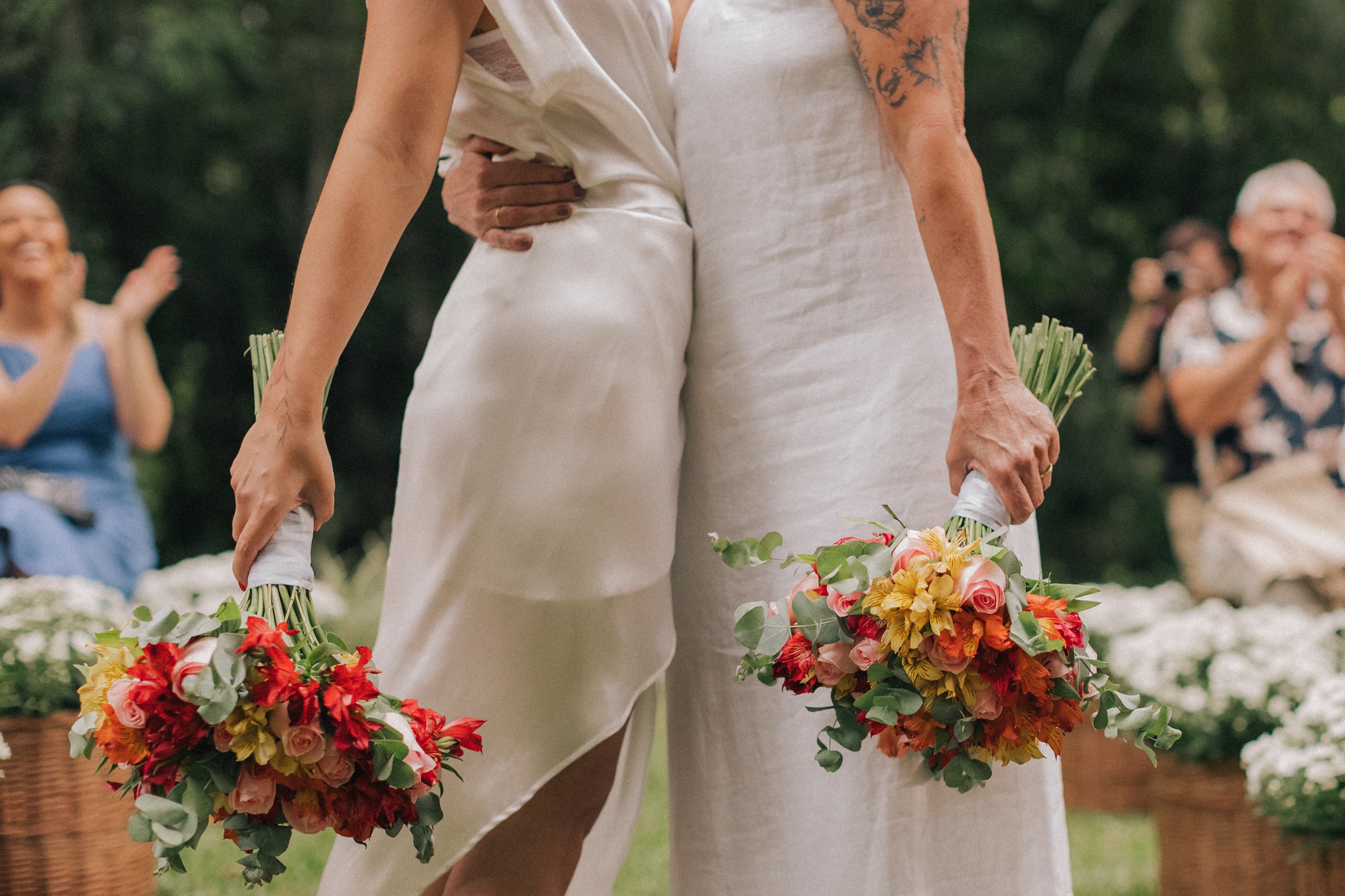 Noivas com dois buques abreaçadas