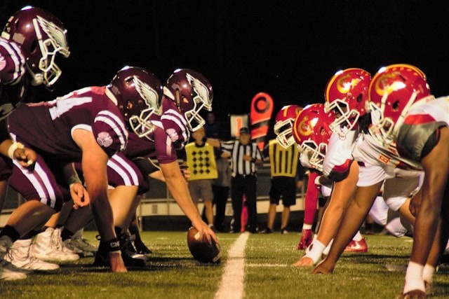 US football players at the starting line before the ball begins