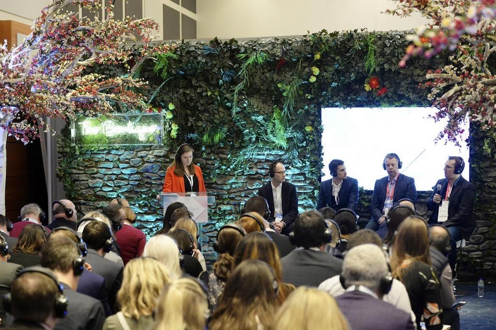 Panel discussion at conference with audience wearing headsets