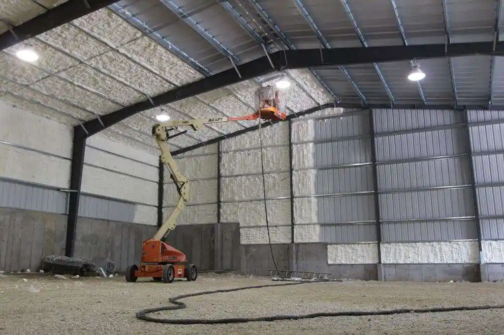 A large commercial warehouse being sprayed with foam insulation