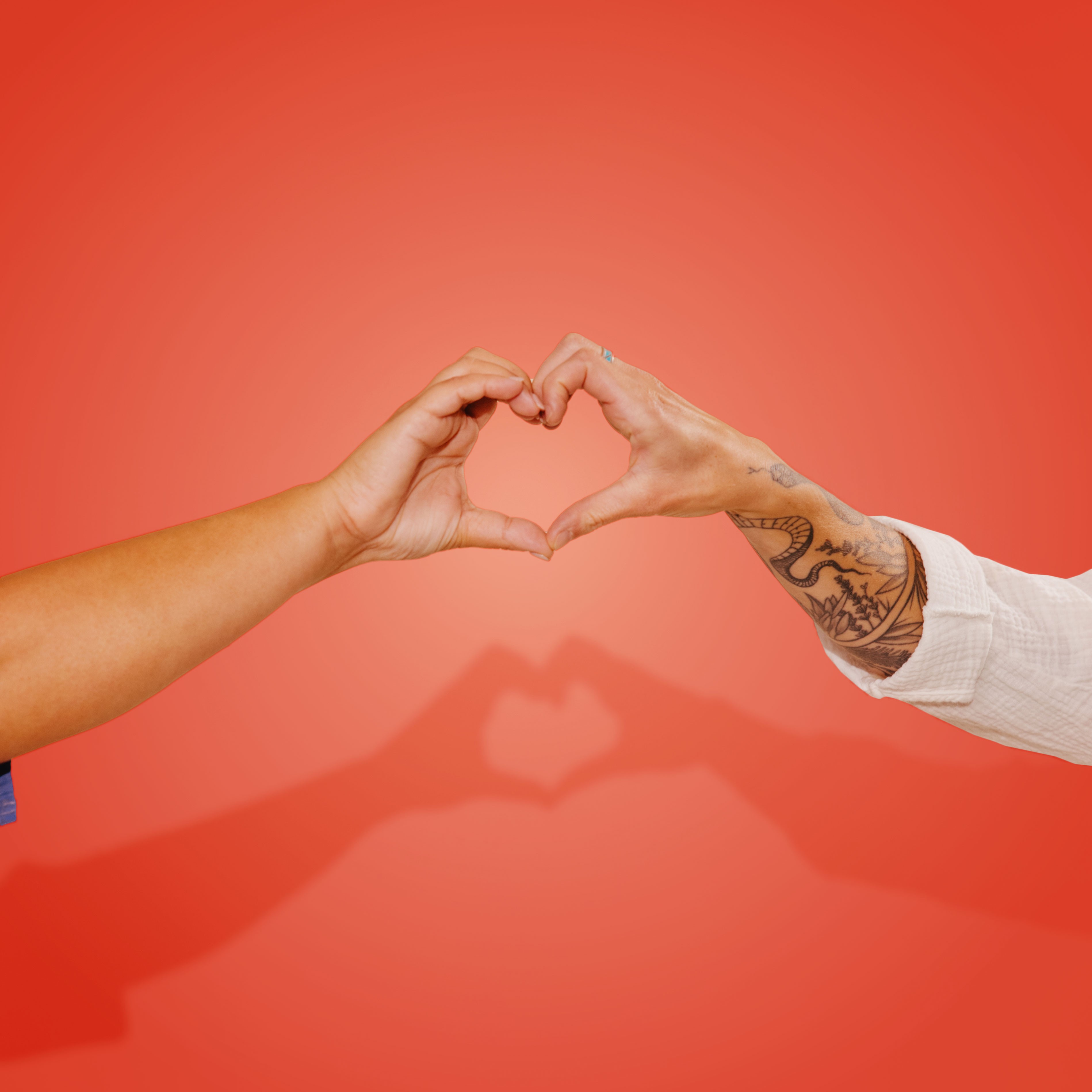 Two-person hand heart on a red backdrop