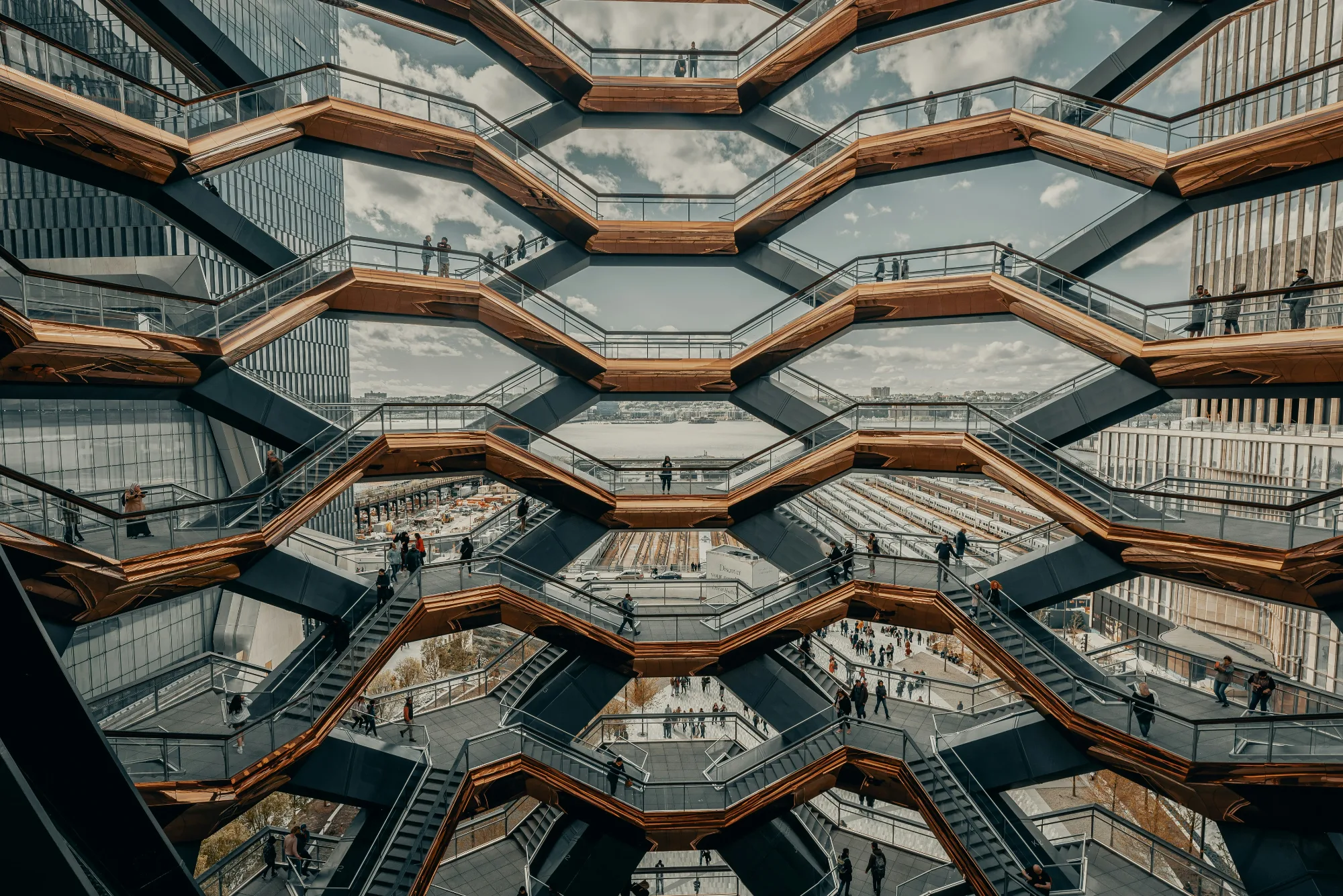 The Vessel, a honeycomb-like structure of stairs in NYC, with people walking up.