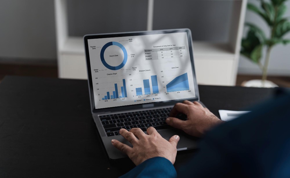 Close-up of a professional analysing financial dashboards and charts on a laptop, illustrating real-time finance management.