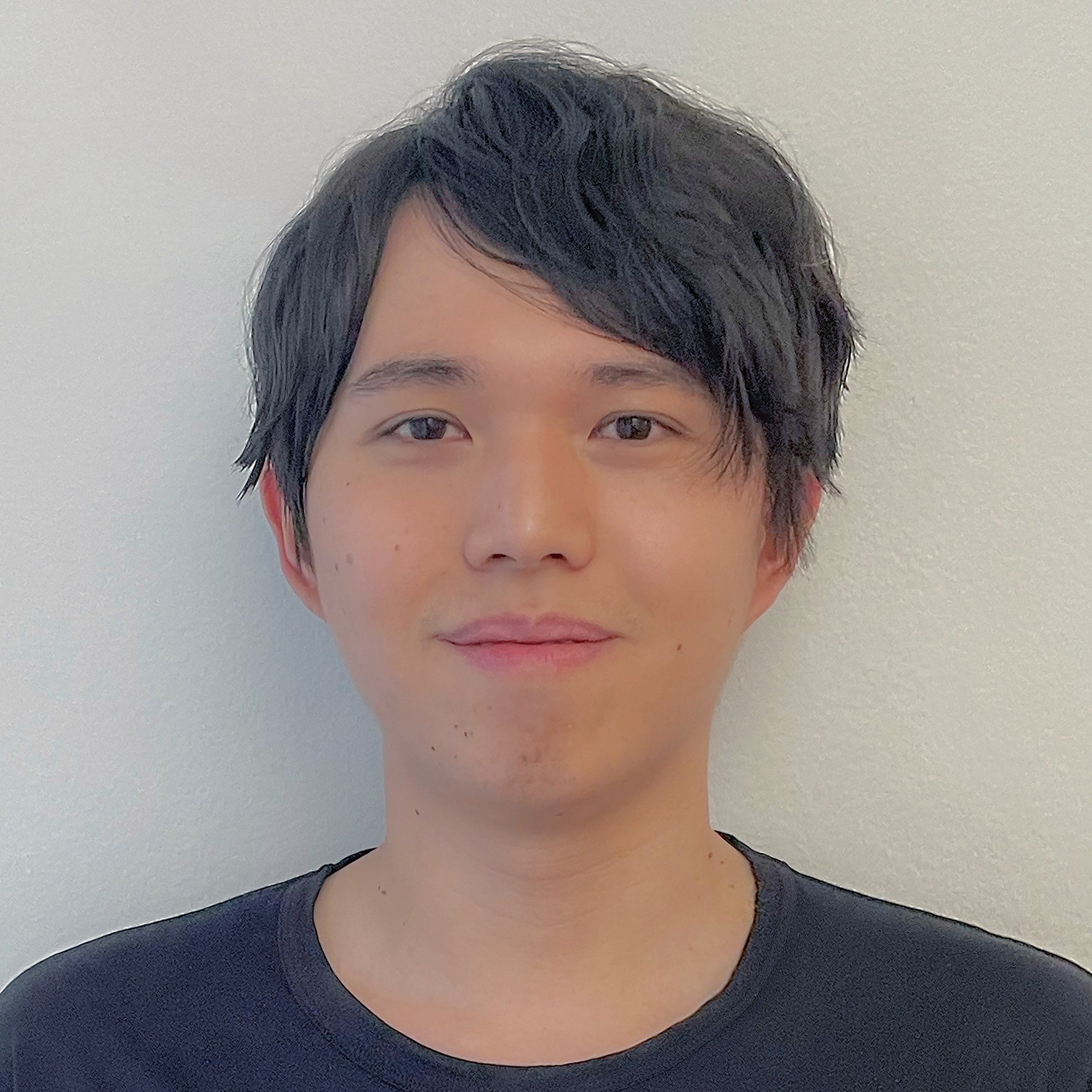 headshot of man with black hair looking at the camera