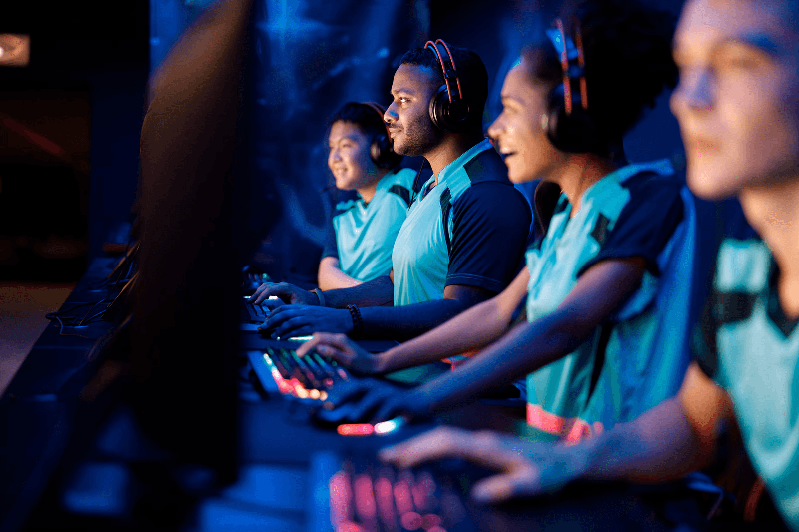A team of esports players wearing headsets and competing together at computers during a gaming tournament.