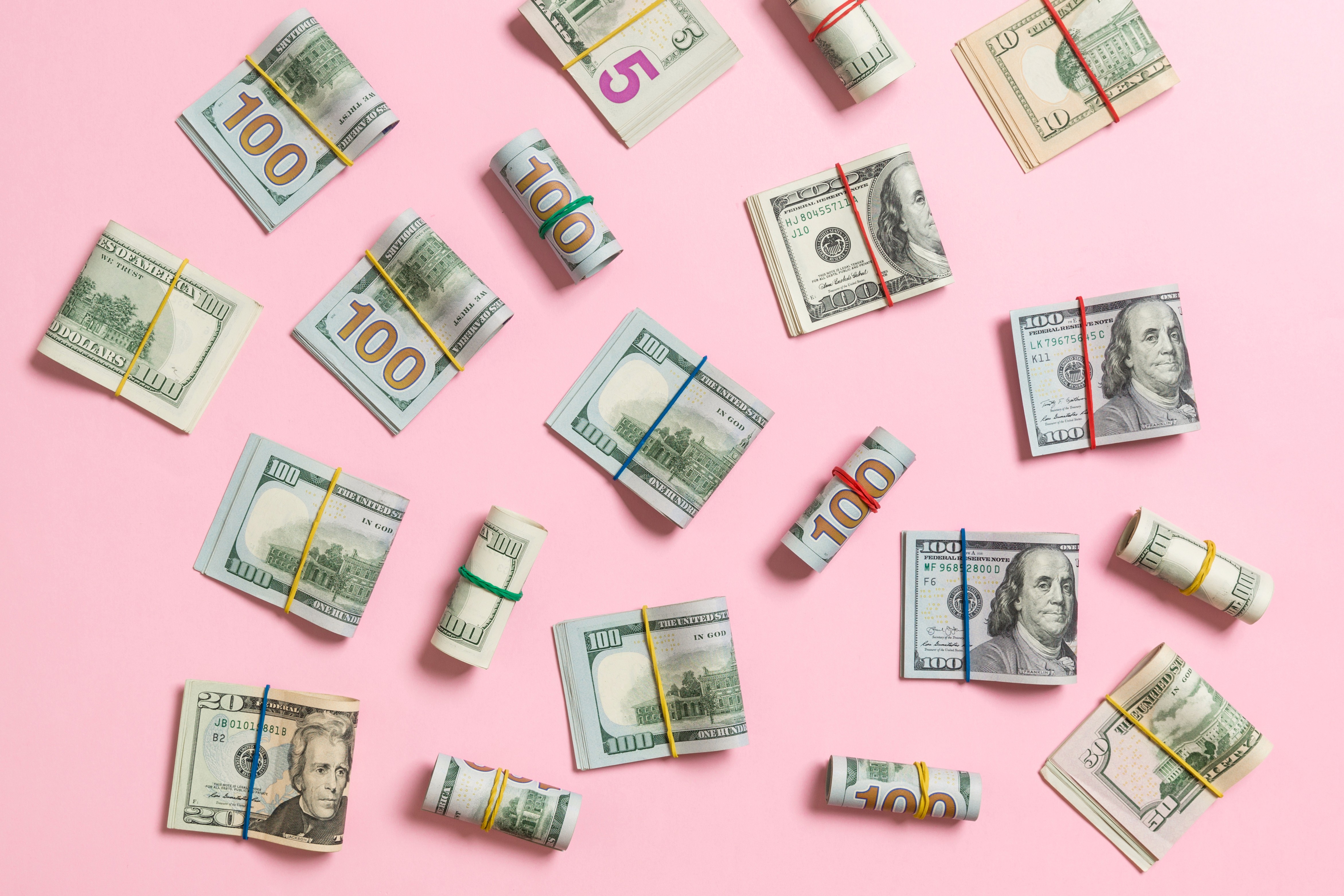 Bundles of money on a pink background